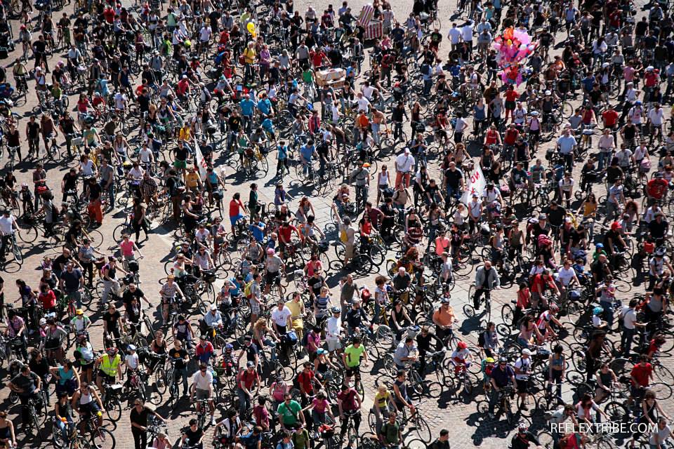Una piazza di Torino gremita di persone in bicicletta