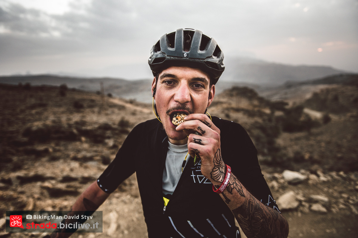 Ciclista si nutre in Oman durante il Biking Man 2019