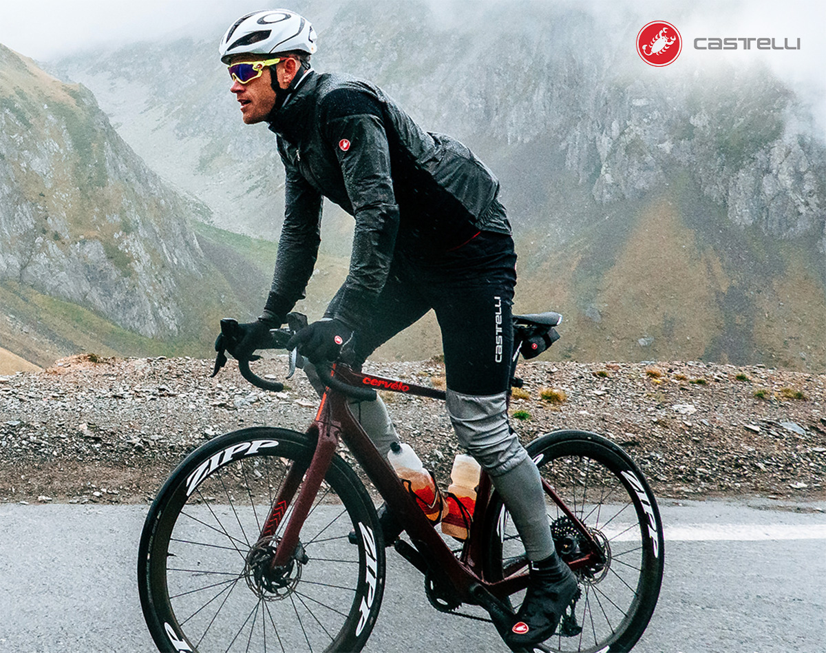 Un ciclista pedala su una bici da corsa indossando la nuova giacca Castelli Idro 3