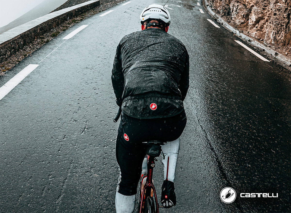 Un ciclista pedala con la pioggia indossando la nuova giacca Castelli Idro 3 2022