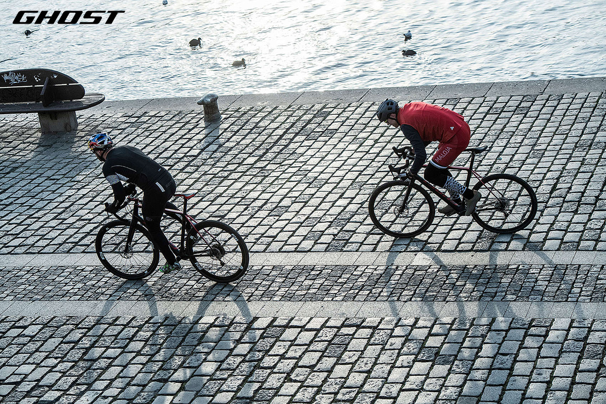 Due ciclisti pedalano sui sanpietrini con delle nuove biciclette gravel Ghost 2022